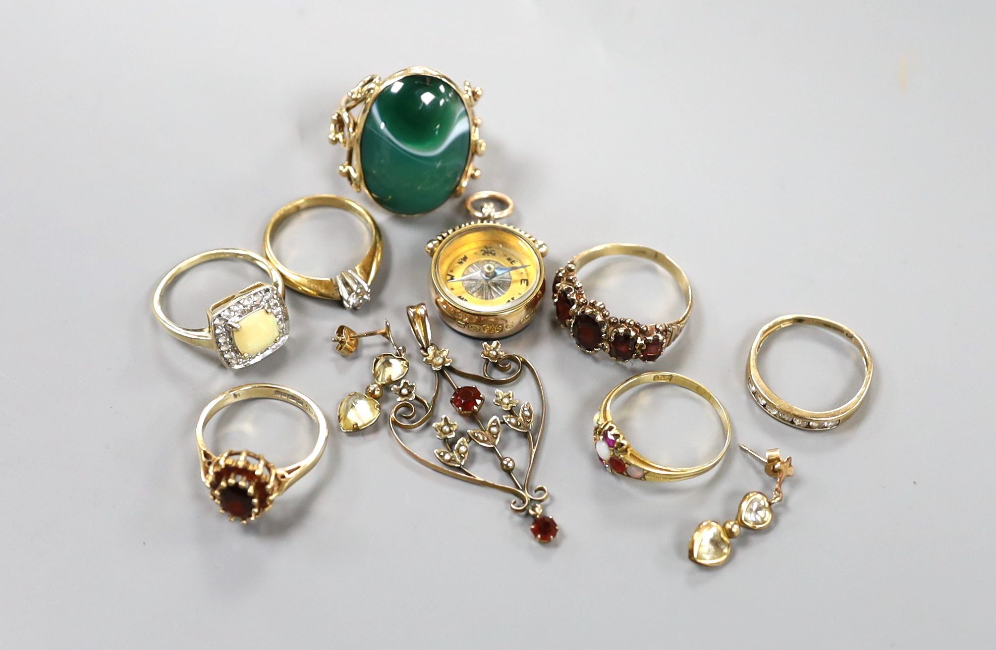 Five assorted modern 9ct gold and gem set rings, a 9ct gold mounted compass fob, a 9ct and gem set pendant and pair of 375 earrings, gross 26.7 grams, together with two yellow metal and gem set rings including five stone